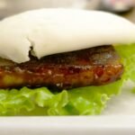 a close up of a plate of food with meat and lettuce